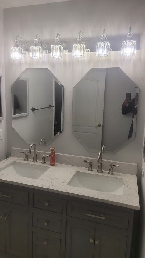 Finished bathroom with white cabinets and gray countertop